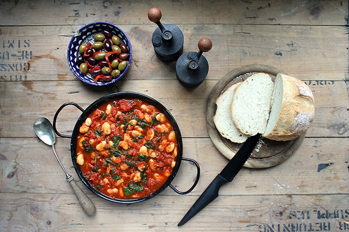 A large bowl of quick and easy Spanish Beans and Tomatoes (vegan and gluten free) with a bowl of olives. 